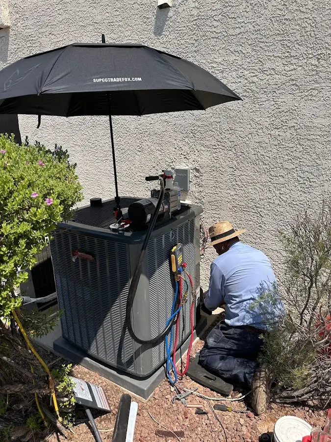 HVAC technician performing outdoor AC maintenance in Whitefish
