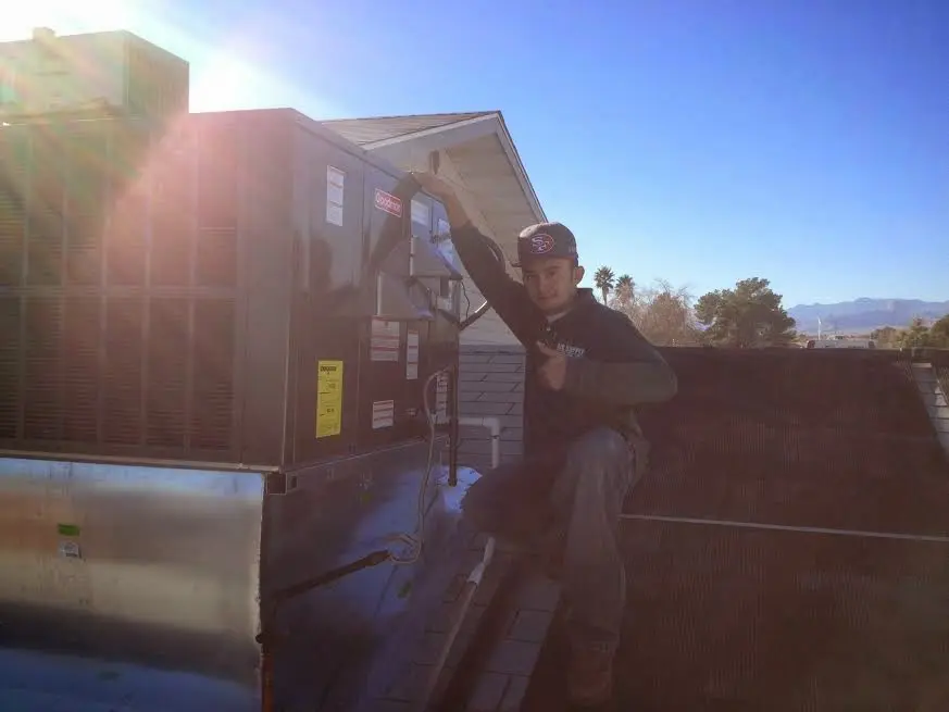 HVAC technician performing HVAC Inspection on a rooftop unit in Whitefish